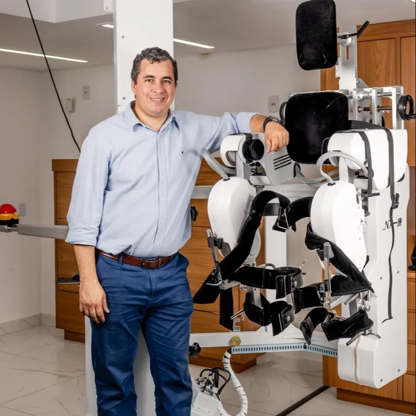 Dr. Thiago Ribeiro Pires ao lado do exoesqueleto A3